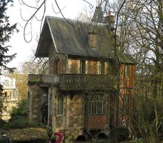 two people are standing in front of an old house