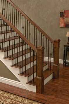 a wooden stair case next to a carpeted floor