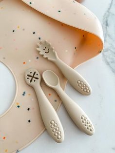 three spoons and two forks on top of a cake