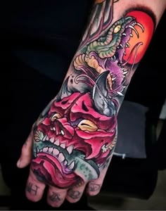 a person with a tattoo on their arm and hand is holding a dragon in the air