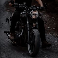 a man riding on the back of a motorcycle down a road