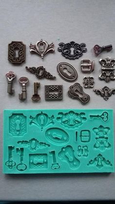 several different metal items are laying on a white surface next to a blue rubber stamp