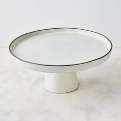 a white cake plate sitting on top of a table