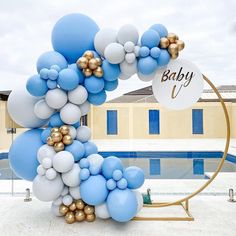 a bunch of balloons that are in front of a pool with a baby sign on it