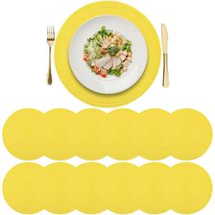 yellow placemats and plates with silverware next to each other on a white surface