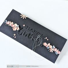 a black card with flowers and the words happy birthday written in white letters on it