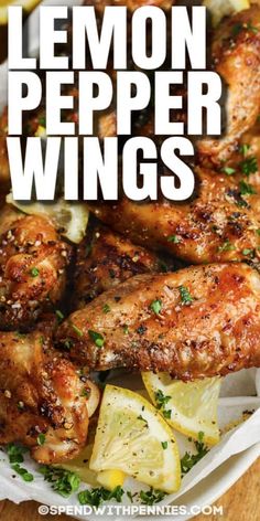 lemon pepper wings in a white bowl with lemon wedges and parsley on the side