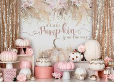 pink and gold party decorations with little pumpkins on the table in front of it