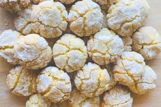 a pile of powdered sugar cookies sitting on top of a wooden table