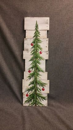 a christmas tree made out of pallet wood with ornaments on the top and bottom