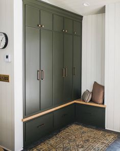 a room with green cabinets and a rug on the floor