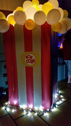 the popcorn box is decorated with balloons and lights