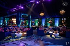 an image of a banquet hall setting with purple and blue decor on the walls, tables and couches