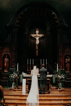 the bride and groom are standing at the alter