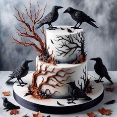 a three tiered cake decorated with black birds on top of it and spooky branches