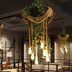 some lights hanging from the ceiling in a room with plants growing out of it's sides