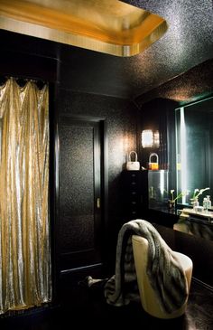 a bathroom with black walls and gold curtains