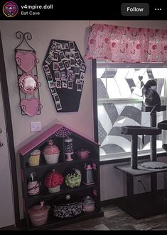 a black cat sitting on top of a table next to a window with pink curtains