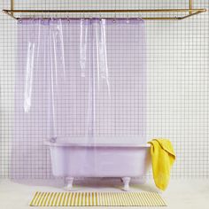 a purple bath tub sitting next to a yellow towel on top of a white floor