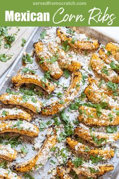 mexican corn ribs on a baking sheet covered in parmesan cheese and cilantro