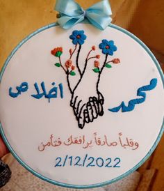 a hand embroidered ornament with blue flowers and the name of someone's birth