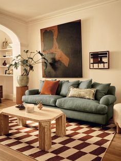 a living room filled with furniture and a large painting hanging on the wall above it