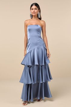 a woman wearing a blue dress with tiered layers and a strapless neckline