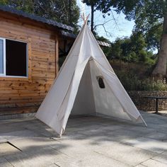 a white teepee sitting in front of a wooden building