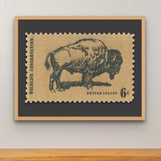 a stamp with an image of a buffalo is hanging on the wall above a shelf