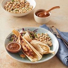 a plate with corn on the cob, beans and salsa