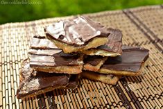 chocolate bars stacked on top of each other on a bamboo tablecloth with grass in the background