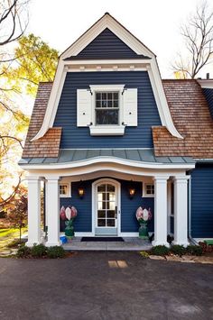 a blue house with white trim and shutters