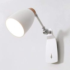 a white wall mounted lamp on the side of a wall with a wooden arm and base