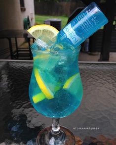 a blue drink with lemon and water in it