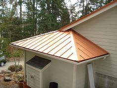 a small white house with a copper roof