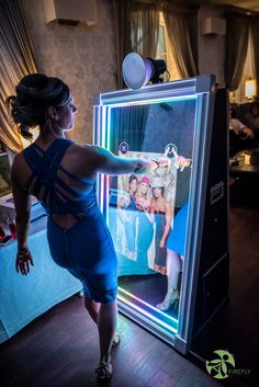 a woman standing in front of a mirror with her hand on the back of it