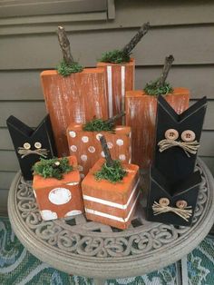 pumpkins decorated with black cats and white polka dots are sitting on a table in front of a house