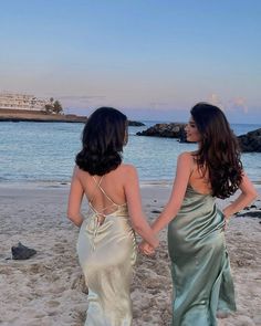 two women walking on the beach holding hands