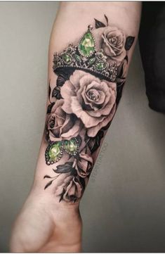 a woman's arm with flowers and a crown on it