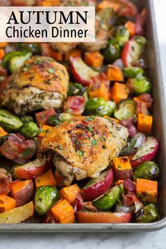 a pan filled with chicken and veggies on top of a table