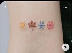 three different colored leaves on the side of a woman's arm, one with sun and snowflakes