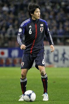 a man standing on top of a soccer field next to a white and blue ball