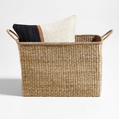 a woven basket with two pillows in it