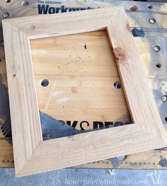 a wooden frame sitting on top of a table next to some screw holes in it