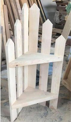 a wooden shelf sitting on top of a floor next to a pile of wood planks