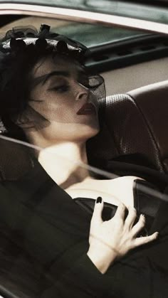 a woman sitting in a car holding a cell phone