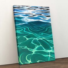 an abstract painting on the wall with blue and green water reflecting off it's surface