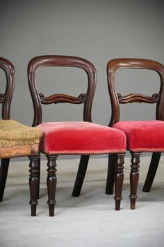 three wooden chairs with red velvet upholstered seats