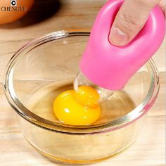 someone is squeezing an egg into a bowl