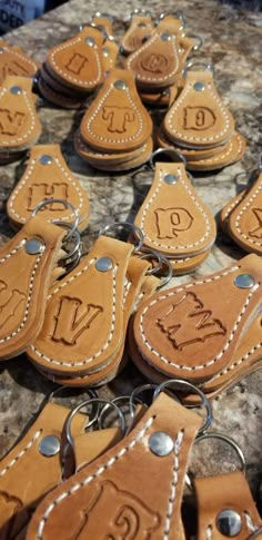 leather keychains with numbers on them sitting on top of a stone countertop